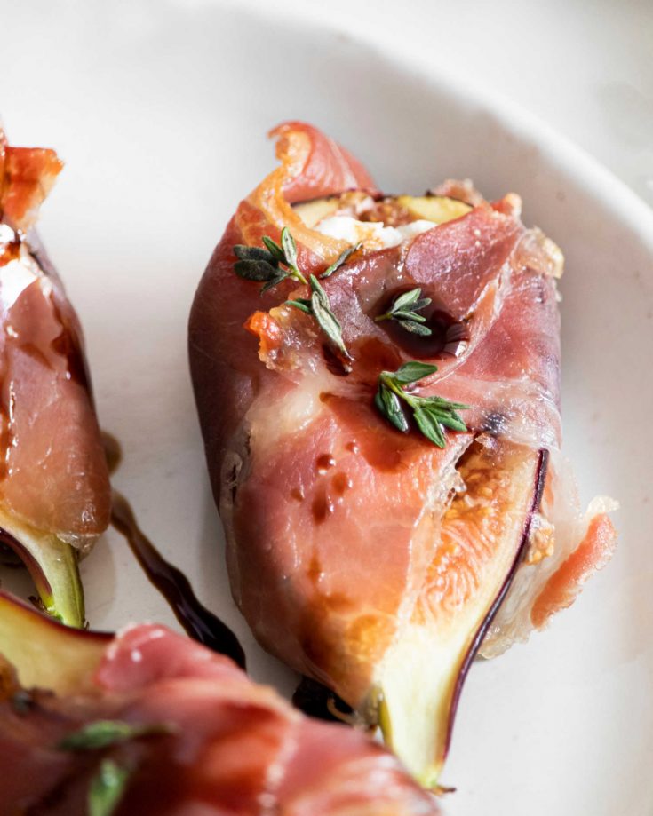 Fig wrapped in prosciutto on a plate